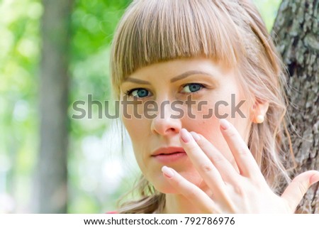 Portrait of beautiful girl with blue eyes on green background