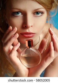 Portrait of the beautiful girl with a bottle of perfume in her hands