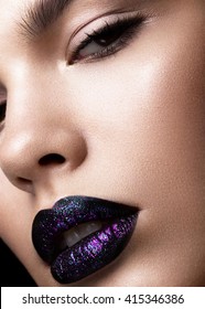 Portrait of a beautiful girl. Brilliant glossy lips closeup. Purple glitter on black lipstick
