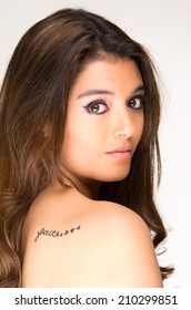 Portrait Of Beautiful Girl With Faith Tatoo On Her Back Isolated On White