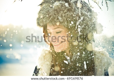Portrait of a beautiful girl in a fur hat in backlit