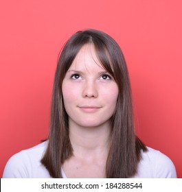 Portrait of beautiful girl looking up against red background