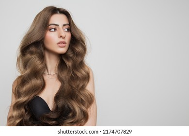 Portrait of a beautiful girl with luxurious curly long hair. White background. - Shutterstock ID 2174707829
