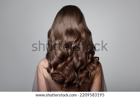 Portrait of a beautiful girl with luxurious curly long hair. Back view. Сток-фото © 