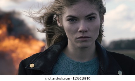 Portrait Of A Beautiful Girl With A Piercing Look And A Car Explosion