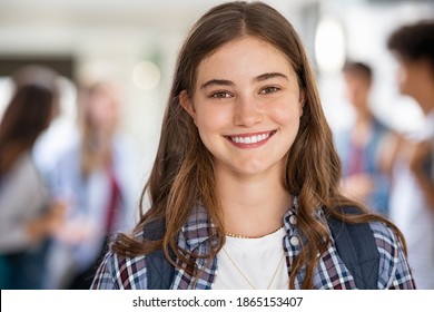 Portrait Of Beautiful Girl Standing In College Campus And Looking At Camera. University Young Woman With Backpack Smiling. Satisfied And Proud Student Girl Standing In High School Hallway.