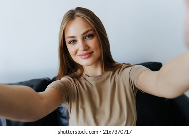 Portrait of beautiful girl taking a self-portrait with her smartphone at home.