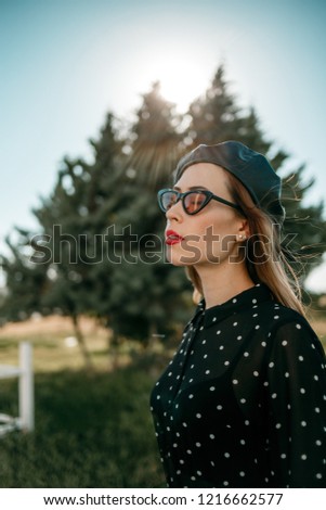 Similar – Blonde junge Frau mit Hut und Sonnenbrille, die bei Sonnenuntergang im Wald mit einem Mobiltelefon ein Foto macht.