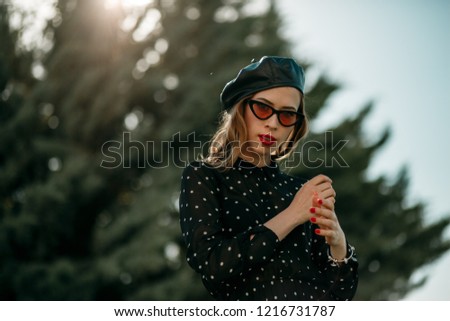 Similar – Blonde junge Frau mit Hut und Sonnenbrille, die bei Sonnenuntergang im Wald mit einem Mobiltelefon ein Foto macht.