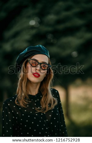 Similar – Blonde junge Frau mit Hut und Sonnenbrille, die bei Sonnenuntergang im Wald mit einem Mobiltelefon ein Foto macht.