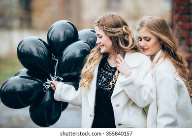 Portrait of beautiful girls in fashionable clothes with black balloons - Shutterstock ID 355840157
