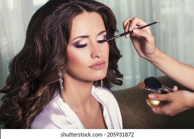 Portrait Of Beautiful Glamour Woman With Dark Curly Hair,make Up Artist Finishing Make Up To Bride At Wedding Morning