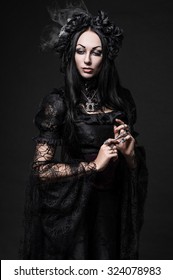 Portrait of beautiful Gothic woman in dark dress in studio