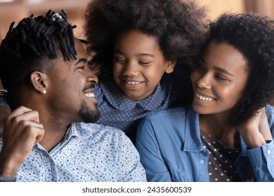 Portrait of beautiful happy African couple with little daughter, close up. Cheerful well-being family hugging smiling looking at each other with love and warmth. Bonding, cherish, parenthood concept - Powered by Shutterstock