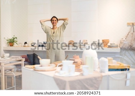 Similar – Woman in work wear in her workshop by table with handmade items