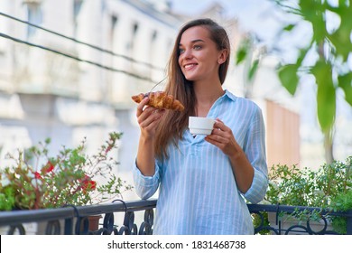 Portrait of a beautiful happy cute joyful smiling romantic woman with coffee cup and fresh baked croissant for french breakfast in the morning on a balcony                      - Powered by Shutterstock