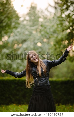 portrait of beautiful happy girl in black leather jacket on the green background