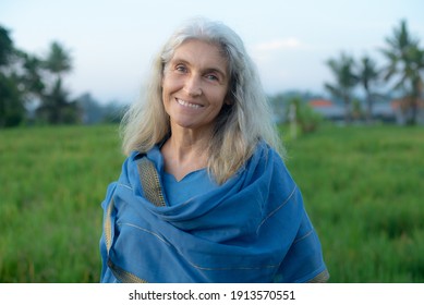 Portrait beautiful happy senior grey-haired woman in a blue oriental dress nature indoors