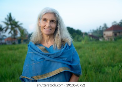 Portrait beautiful happy senior grey-haired woman in a blue oriental dress nature indoors