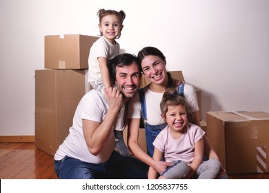 Portrait Of A Beautiful Happy And Smiling Family Just Arrived In The New House To Start A New Journey Together. Concept Of: Love, Family, Home.