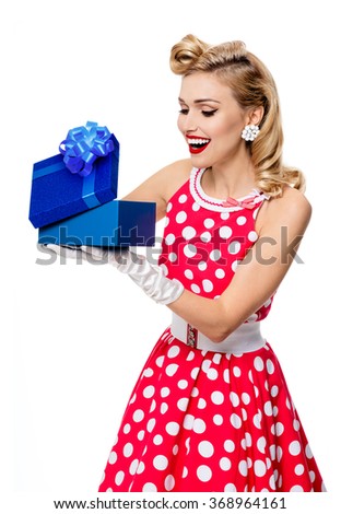 Portrait of beautiful happy smiling woman dressed in pin-up style red dress in polka dot and white gloves, isolated. Caucasian blond model posing in retro fashion and vintage concept studio shoot.