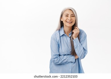 Portrait Of Beautiful, Healthy And Happy Old Korean Woman, Laughing And Smiling, Standing Over White Background