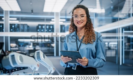 Portrait of a Beautiful Hispanic Female Wearing Glasses, Using Tablet Computer, Looking at Camera and Smiling. Businesswoman, Information Technology Manager, Robotics Engineering Specialist.