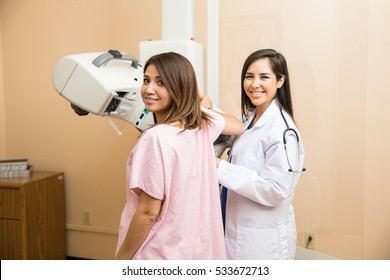 Portrait of a beautiful Hispanic patient and her doctor in the middle of a mammography at a hospital