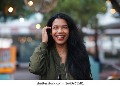 Portrait beautiful hispanic woman smiling happy in city evening with lights in background