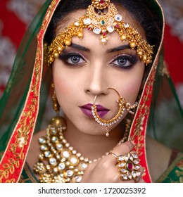 Portrait of beautiful Indian bride, happy Indian bride wearing heavy jewelry 