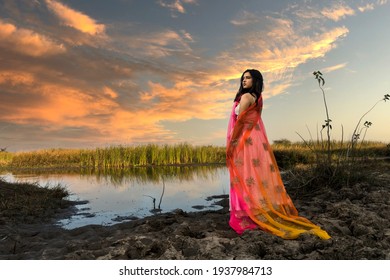 Portrait of beautiful Indian girl wearing Indian traditional dress. Young woman in traditional Indian costume lehenga choli with fashionable hairstyle poses