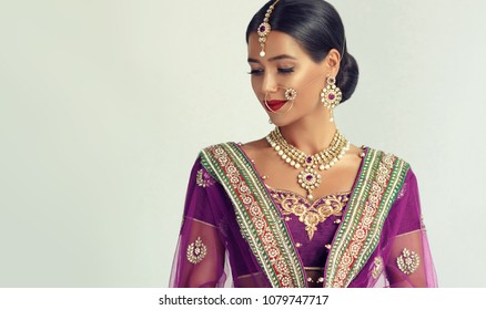 Portrait of beautiful indian girl. Young hindu woman model with kundan jewelry set. Traditional India costume lehenga choli or sari