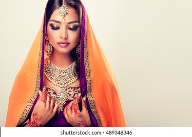 Portrait Of Beautiful Indian Girl . Young Hindu Woman Model  With Tatoo Mehndi  And Kundan Jewelry . Traditional Indian Costume Lehenga Choli .