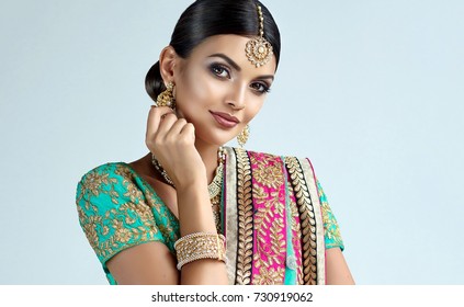 Portrait of beautiful indian girl. Young hindu woman model with kundan jewelry set. Traditional Indian costume lehenga choli or sari