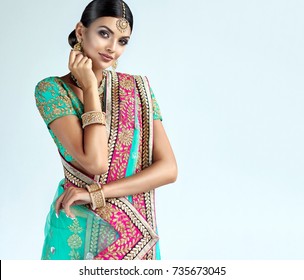 Portrait of beautiful indian girl. Young hindu woman model with kundan jewelry set. Traditional Indian costume lehenga choli or sari