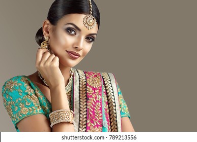 Portrait of beautiful indian girl. Young hindu woman model with kundan jewelry set. Traditional India costume lehenga choli or sari
