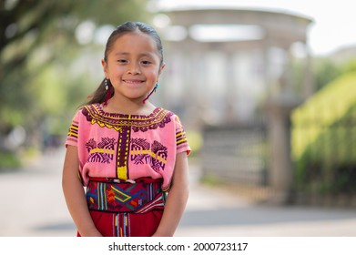 Portrait Of A Beautiful Indigenous Girl With A Colorful Dress From Quiche.