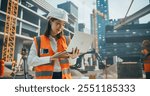 Portrait of a Beautiful Japanese Female Civil Engineer Working on a Laptop at a Construction Site. Young Asian Woman Standing Outdoors, Using Computer for Planning and Developing a Real Estate Project