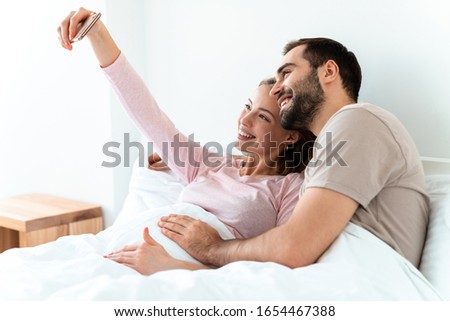 Similar – Image, Stock Photo Man and pregnant woman looking baby clothes