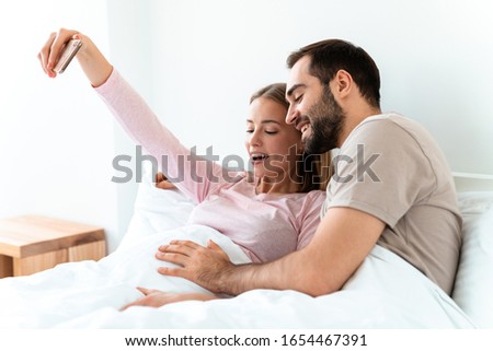 Similar – Image, Stock Photo Man and pregnant woman looking baby clothes