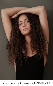portrait of beautiful latina girl with curly hair looking at the camera from the corner of the eye