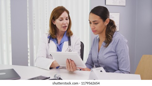 Portrait Of Beautiful Latina Patient Consulting With Doctor On Tablet