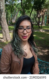 Portrait Of A Beautiful Latina Woman Sitting On A Bench In The Park