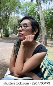 Portrait Of A Beautiful Latina Woman Sitting On A Bench In The Park