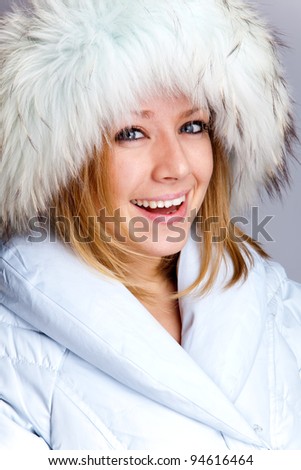 Portrait of a beautiful laughing woman in the white fur coat