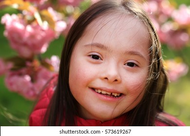 Portrait of beautiful little girl in blossom park