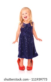 A Portrait Of A Beautiful Little Girl In A Blue Dress And Red Too Big Heels Smiling Over White Background