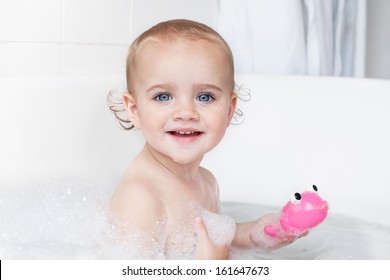 Portrait of a beautiful little girl playing in bathtub
