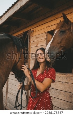 portrait of a beautiful long-haired girl and a horse in the stable	