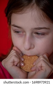 Portrait Of Beautiful, Lovely, L Child Girl, Bites Cookies On Red Background. Girl Eating Cookies. Girl 9 Years Old Portrait. The Concept Of Food And Man. Teenager